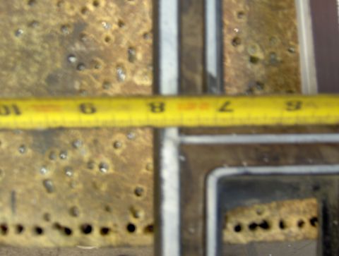 1978 Ford Bronco - A yellow measuring tape is placed over a textured, metallic surface with numerous small holes. The tape shows markings from 6 to 10, with s…