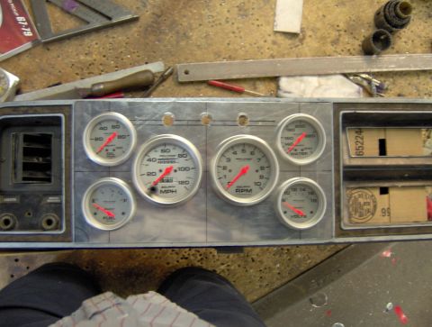1978 Ford Bronco - A custom aluminum gauge cluster is being installed into a vehicle dashboard. The cluster features multiple gauges including RPM, MPH, oil p…