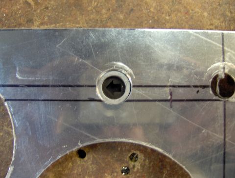 1978 Ford Bronco - A close-up view of a metal plate with two circular cutouts and a central circular component with an arrow pointing left. Black lines are dr…