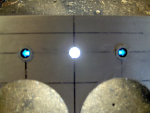 1978 Ford Bronco - A close-up view of a metal panel with two illuminated blue arrows pointing left and right, and a bright white light in the center. The pane…