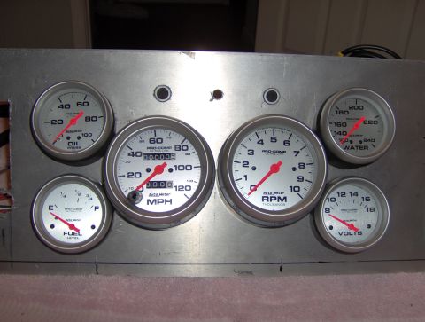 1978 Ford Bronco - A set of Auto Meter gauges, including oil pressure, speedometer, tachometer, fuel level, water temperature, and volts, are mounted on a bru…