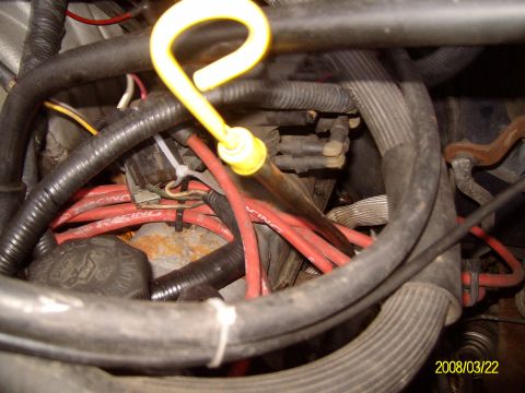 1988 Ford Bronco - A close-up view of an engine bay, focusing on various hoses, wires, and the oil dipstick.