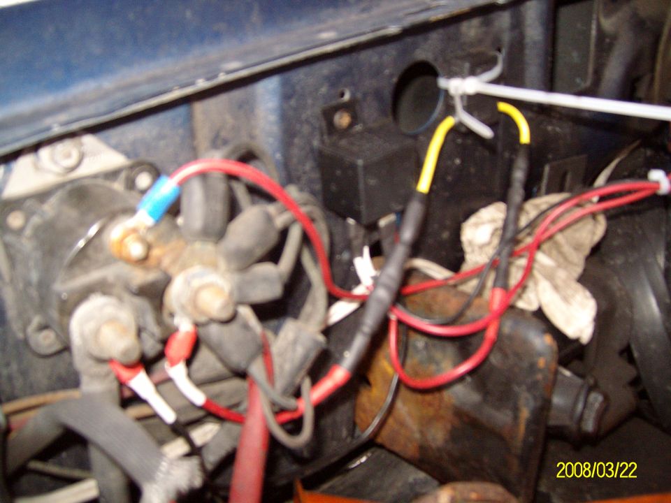 Engine bay wiring with red and yellow wires connected to a junction block, blue and red wire connectors visible