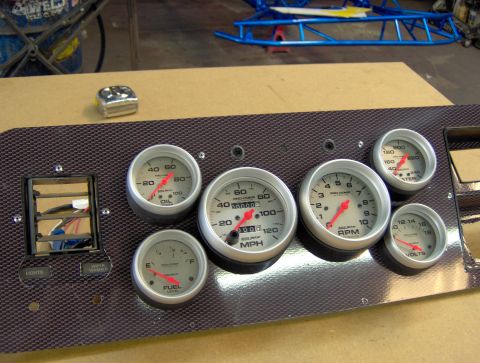 1978 Ford Bronco - A collection of aftermarket gauges are mounted on a textured panel, ready for installation.