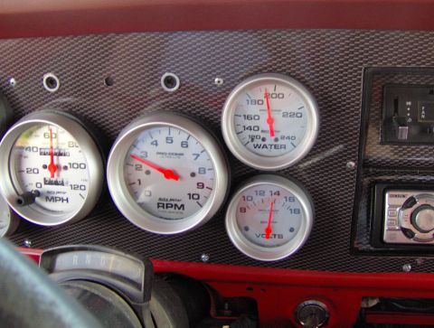 1978 Ford Bronco - A close-up view of a vehicle's dashboard gauges and aftermarket stereo system.