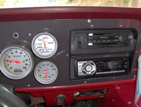 1978 Ford Bronco - Close-up of a vehicle's dashboard showing various gauges and an aftermarket stereo system.