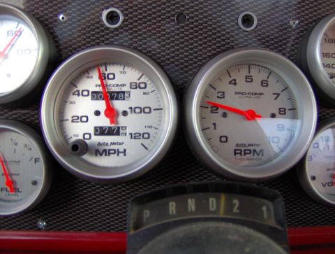 1978 Ford Bronco - The dashboard features several Auto Meter gauges, including a speedometer and tachometer, set against a carbon fiber-like background.