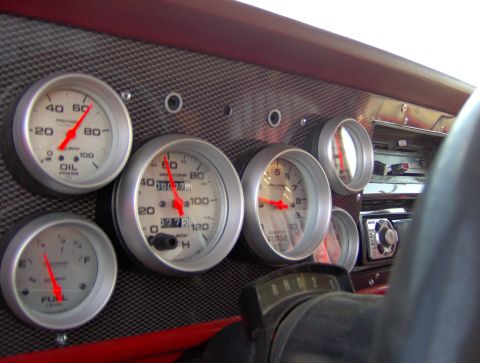1978 Ford Bronco - Aftermarket gauges installed on a vehicle's dashboard, showing oil pressure, fuel, RPM, and speed.