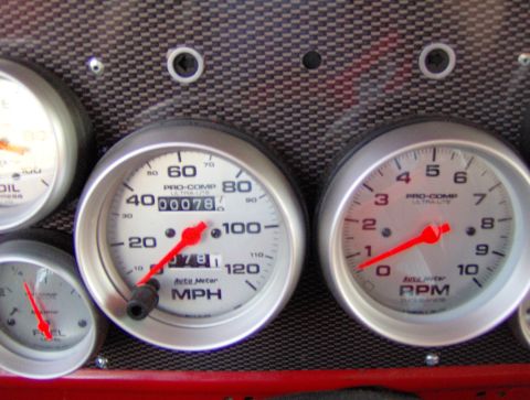 1978 Ford Bronco - A collection of Pro-Comp Ultra-Lite gauges are mounted on a carbon fiber-patterned dash panel.