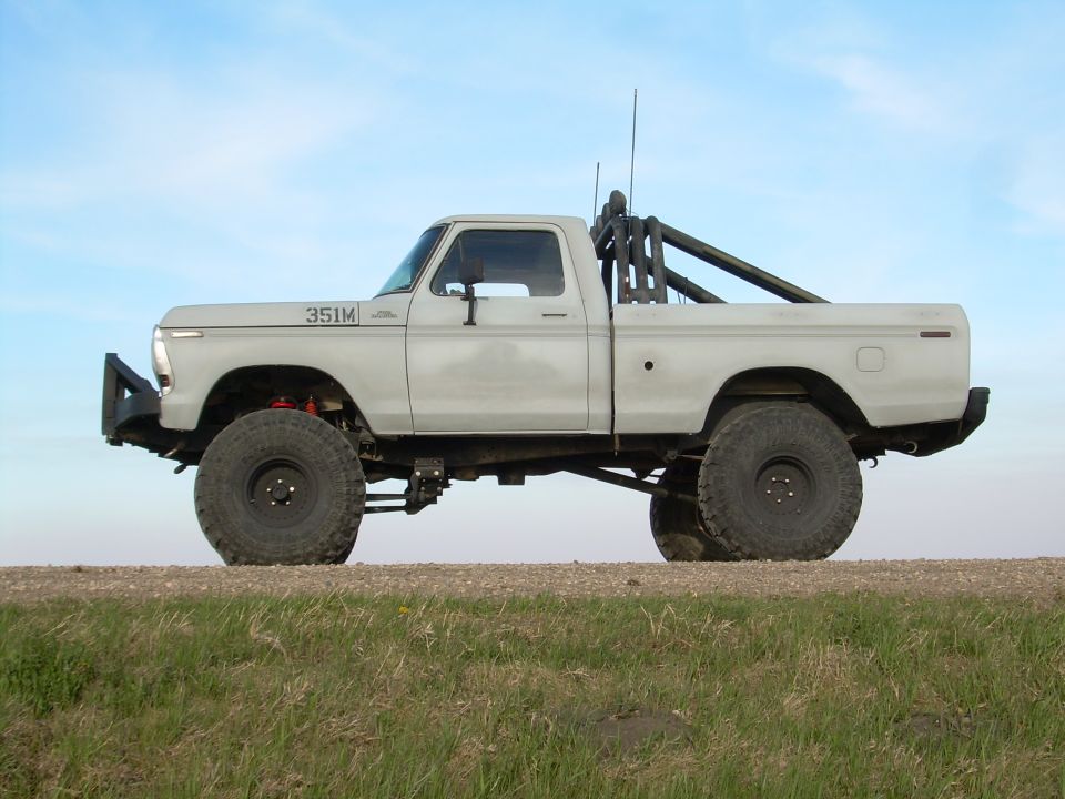 1978 Ford F-150 lifted pickup truck with roll cage and large tires, side view