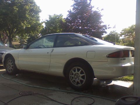 1997 Ford Probe - A white 1997 Ford Probe is parked on a driveway with trees in the background.