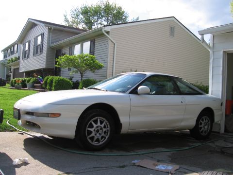 1997 Ford Probe - A white 1997 Ford Probe is parked on a driveway in front of a house.