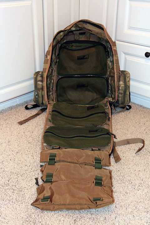 1991 Ford Bronco - An open backpack with various compartments is displayed on a carpeted surface.