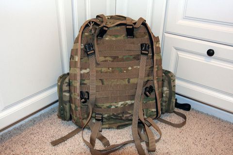 1991 Ford Bronco - A multi-camouflaged backpack with numerous straps and buckles is positioned on a carpeted floor.