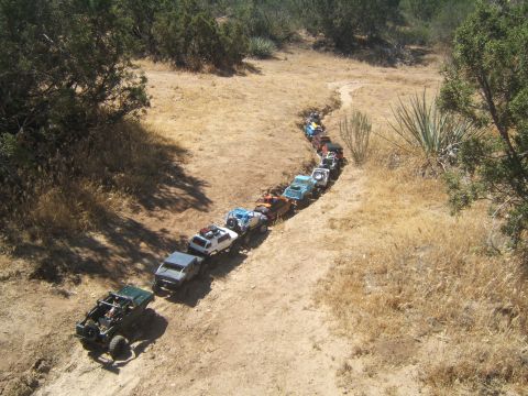 1988 Ford Bronco - RC off-road vehicles navigate a trail in a dry, arid landscape.