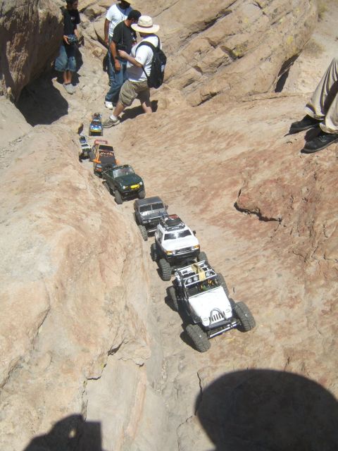 1988 Ford Bronco - Several RC off-road vehicles navigate a steep, rocky terrain.