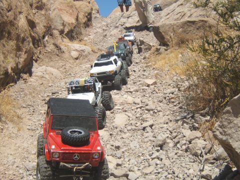 1988 Ford Bronco - A convoy of remote-controlled off-road vehicles navigates a steep, rocky trail in Vasquez Rocks.