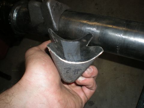 1993 Ford Bronco - Custom metal bracket part being held, with a large diameter metal tube visible.