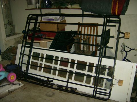 2004 Jeep Wrangler - A metal rack and a white door are stored indoors, with various items in the background.