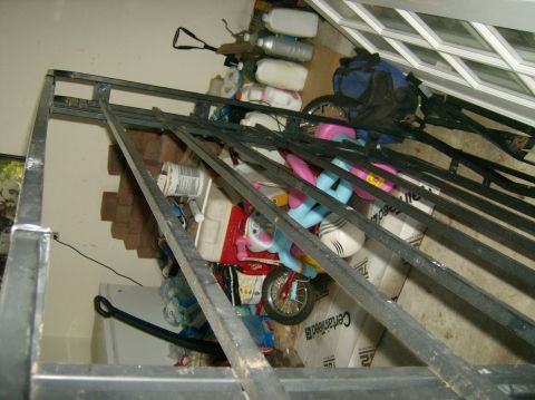 2004 Jeep Wrangler - A garage is filled with various items, including shelving, boxes, toys, and cleaning supplies, obscuring any potential vehicles.