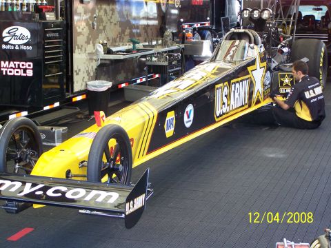 1973 Ford Mustang - A U.S. Army dragster is being serviced in a garage environment, with tools and equipment visible.