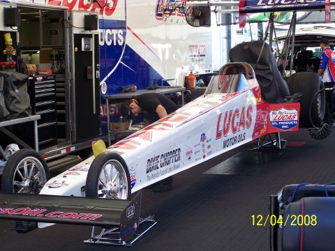 1973 Ford Mustang - A dragster with Lucas Motor Oils branding is being worked on in a garage setting.