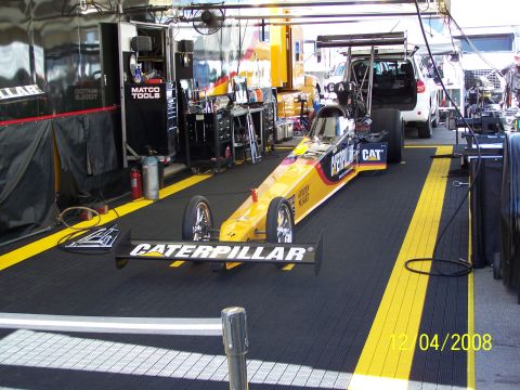 1973 Ford Mustang - A dragster sits in a garage bay, ready for the next race.