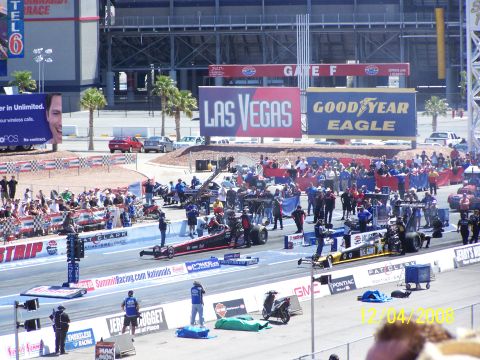 1973 Ford Mustang - A drag racing event takes place with multiple vehicles and a large crowd in attendance.