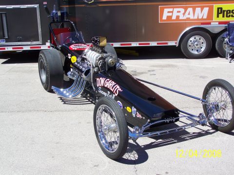 1973 Ford Mustang - A black dragster with "Don Garlits Swamp Rat III" text is parked in front of a trailer.