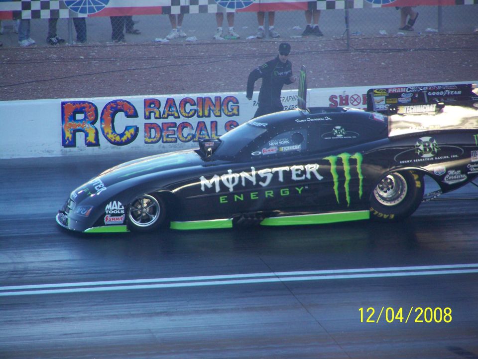 Black drag car with Monster Energy livery, side view