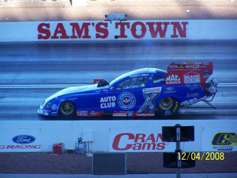 1973 Ford Mustang - A blue drag racing car with numerous sponsor decals is on the track at Sam's Town.
