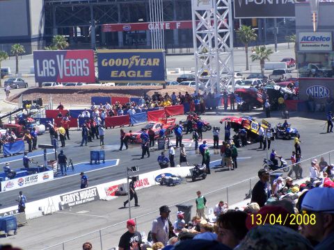 1973 Ford Mustang - A busy drag racing event with multiple vehicles and a crowd of spectators.