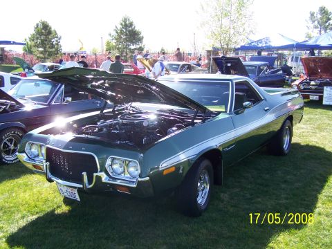 1973 Ford Mustang - A green Ford Ranchero pickup truck is displayed with its hood open at an outdoor car show.