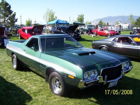 1973 Ford Mustang - A green 1972 Ford Ranchero is displayed at a car show, with other vehicles visible in the background.