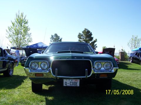 1973 Ford Mustang - Front view of a 1970 Ford Torino GT at a car show. A second vehicle is partially visible on the left.