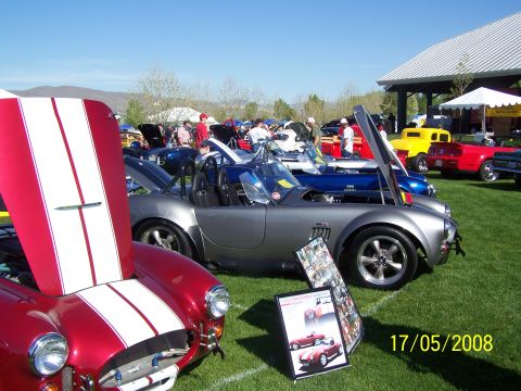 1973 Ford Mustang - Several classic cars are displayed on a sunny day at an outdoor car show.
