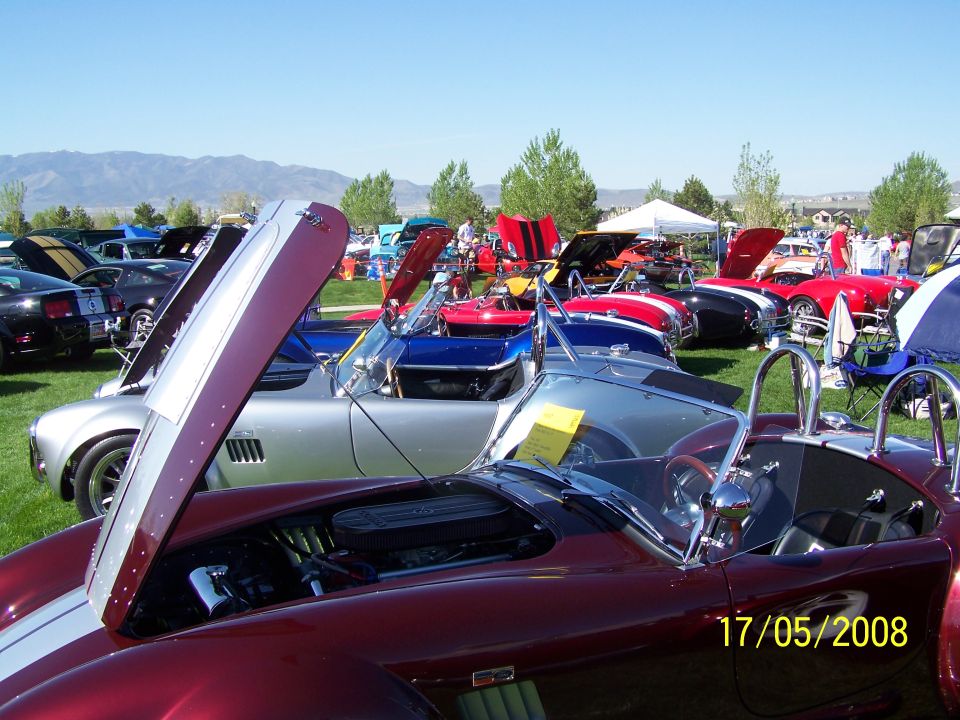 Maroon Shelby Cobra with hood open, parked at a car show