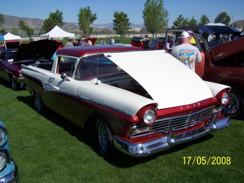 1973 Ford Mustang - A two-tone red and white 1950s era Ford Ranchero is parked on a grassy field with its hood open. The vehicle is displayed at an outdoor eve…