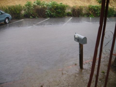 1990 Ford Bronco - A flooded parking lot with a mailbox in the foreground during a heavy rain. A portion of a teal colored car is visible on the left side of…