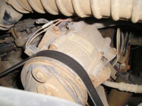 1996 Ford Bronco - Close-up view of an engine's belt and pulley system, showing mechanical components.