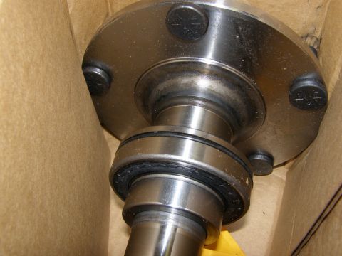 1993 Ford Bronco - A close-up view of a metal axle assembly with a bearing and seal, possibly a part for a 1993 Ford Bronco, is shown inside a cardboard box.