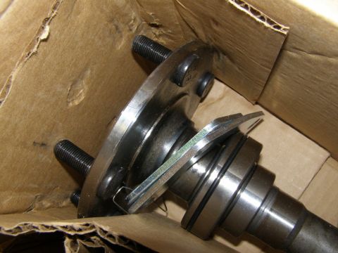1993 Ford Bronco - A close-up view of a metal automotive part with threaded studs, likely a wheel hub assembly, resting inside a cardboard box.