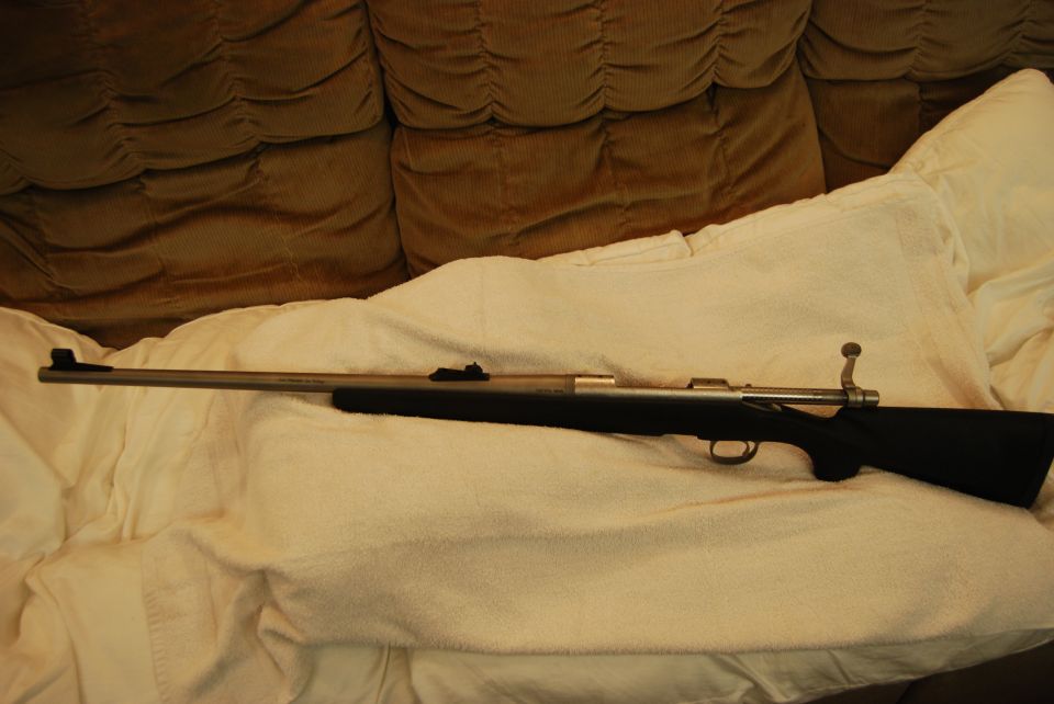 A rifle on a white blanket.