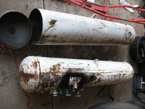 1989 Ford F-250 - Two large, white, cylindrical tanks with significant rust and some black spray paint are shown on a concrete surface. One tank is open at o…