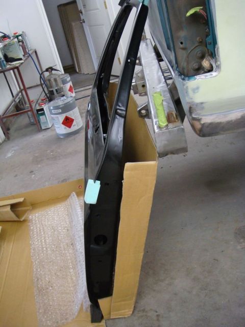 1996 Ford Bronco - Photograph of a painted vehicle door propped on its edge in a shop, not a technical document.