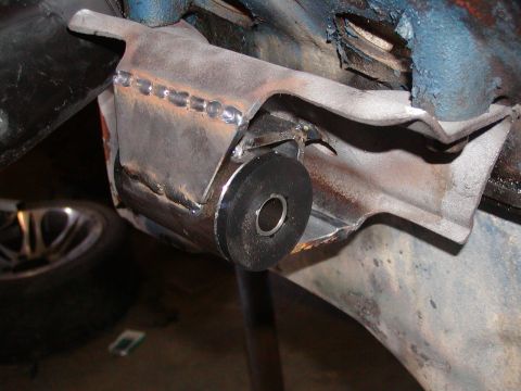 1991 Ford Bronco - Close-up of a modified frame bracket with a rubber bushing, indicating repair or modification work.