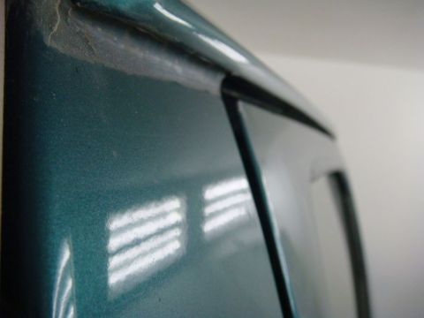 1996 Ford Bronco - Close-up photograph of a glossy teal painted body panel edge, not a technical document.