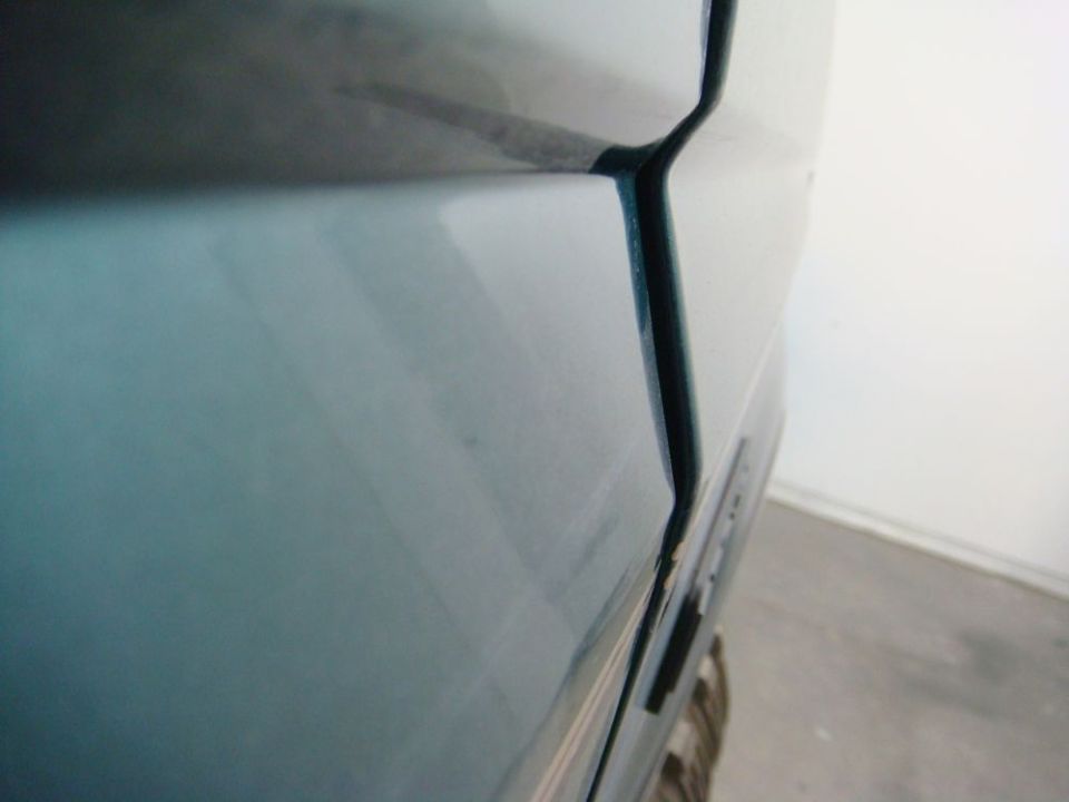Close-up of a painted teal panel gap on a vehicle body