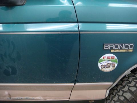 1996 Ford Bronco - Photograph of a teal Ford Bronco's painted side with badging and sticker, not a technical document.