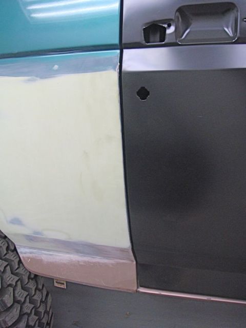 1996 Ford Bronco - A car door is shown with bodywork in progress, revealing primer and filler.